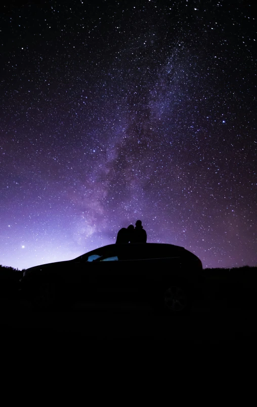 a car under stars on a purple sky