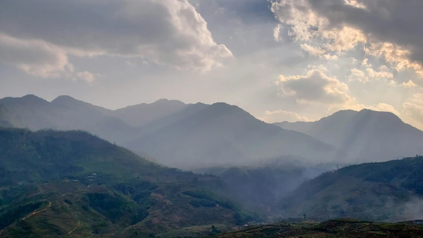 mountains are in the distance behind sun rays