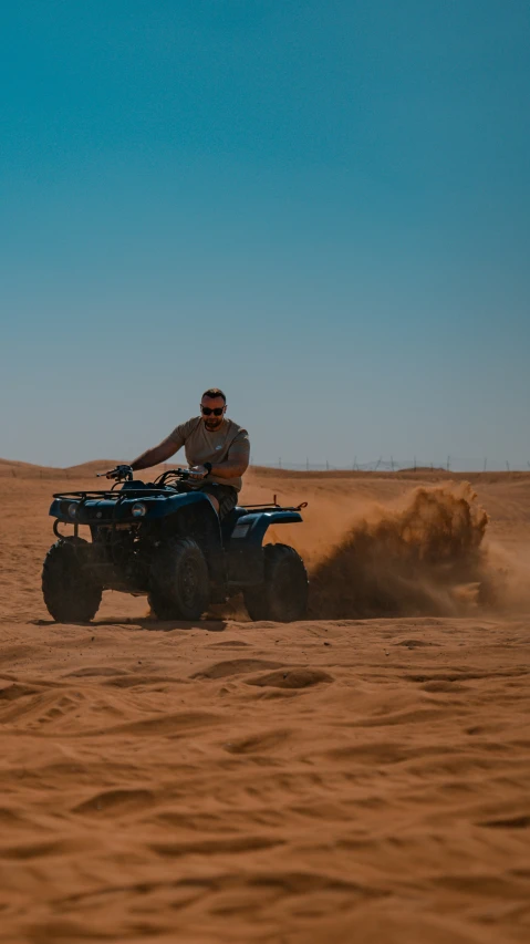 an atv is driving in the middle of the desert