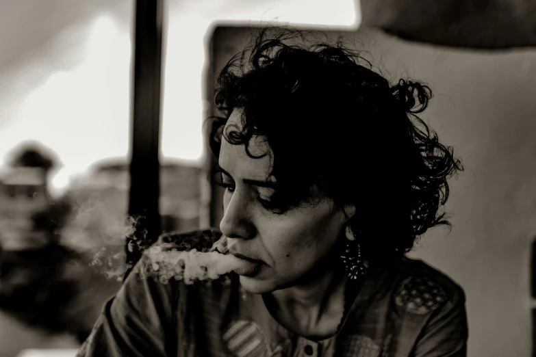 a woman with curly hair sitting at a table eating food