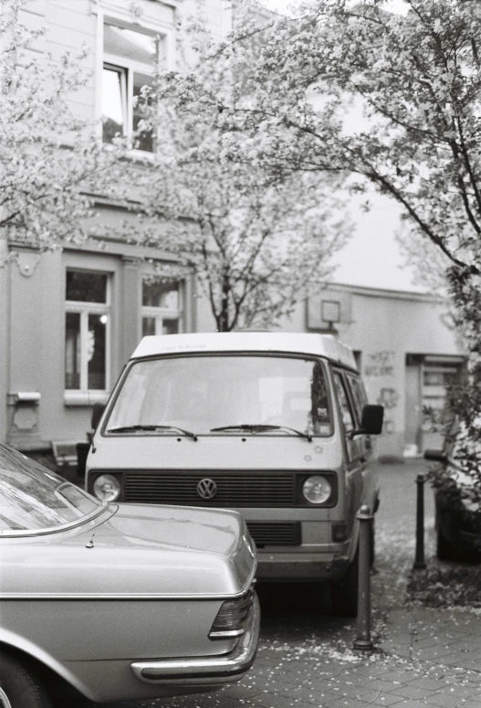 two cars parked on a street with trees in the background