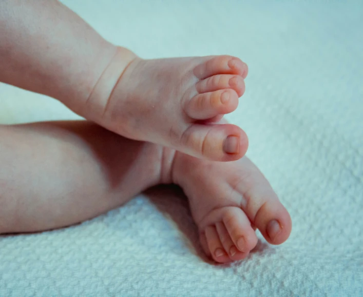 a child's feet laying on top of a bed