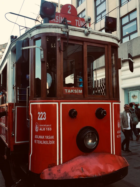 a red trolly car driving down the street