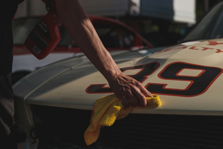 a close up of someone polishing a car