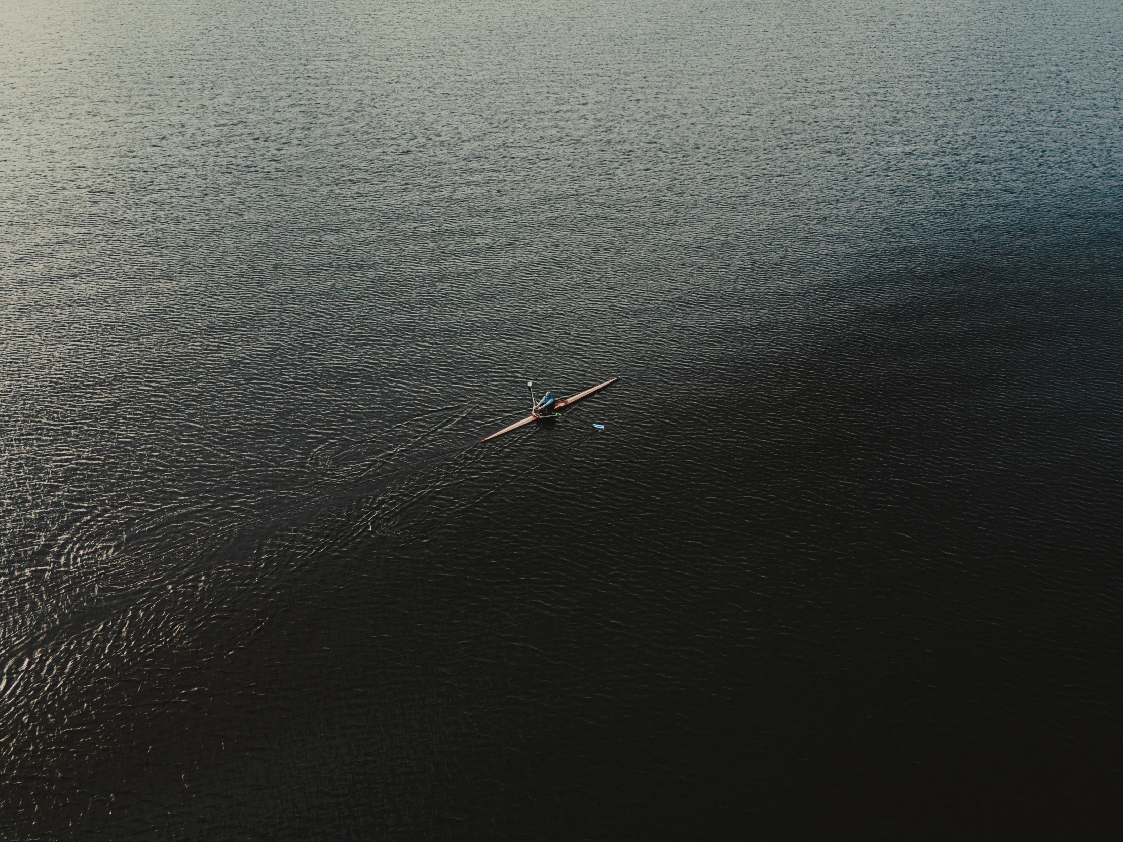 a single canoe sailing on the open ocean