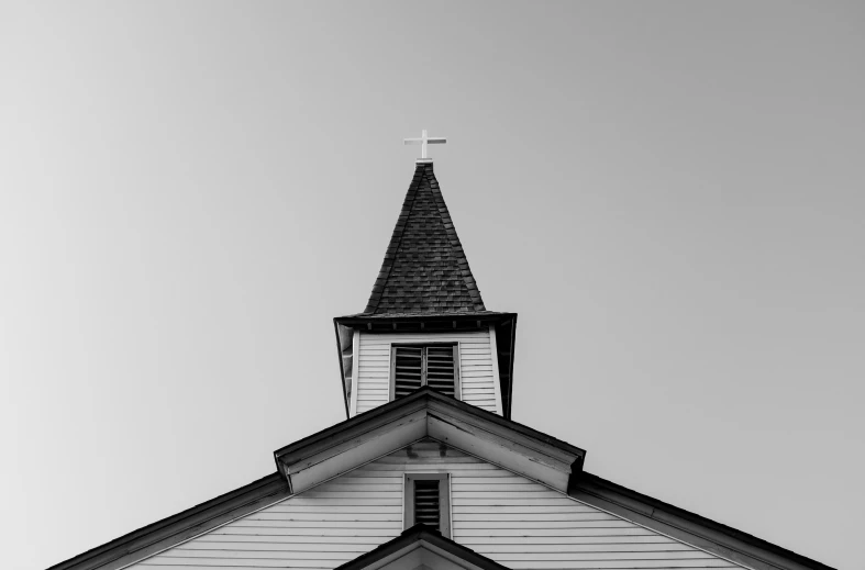 a white church with a steeple and a cross
