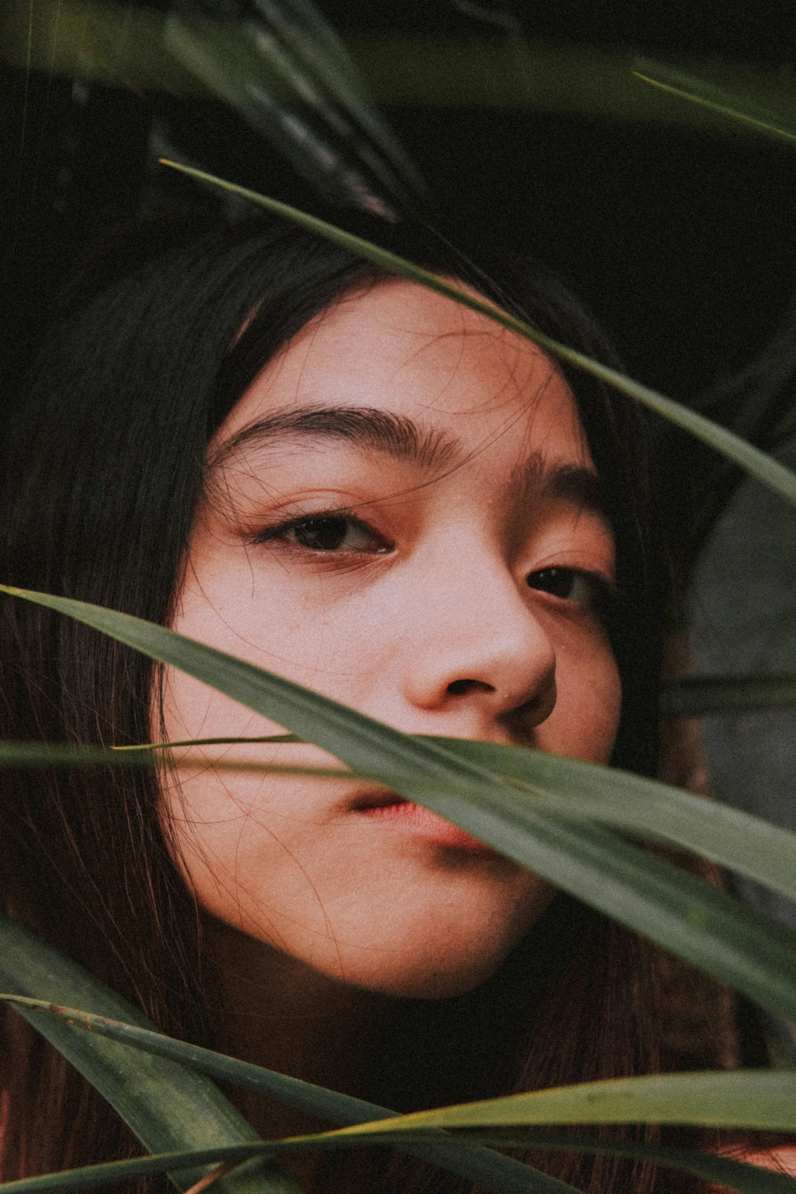 a young asian woman staring into the distance with eyeshade