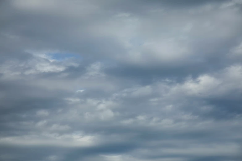 an airplane flying across a cloudy sky