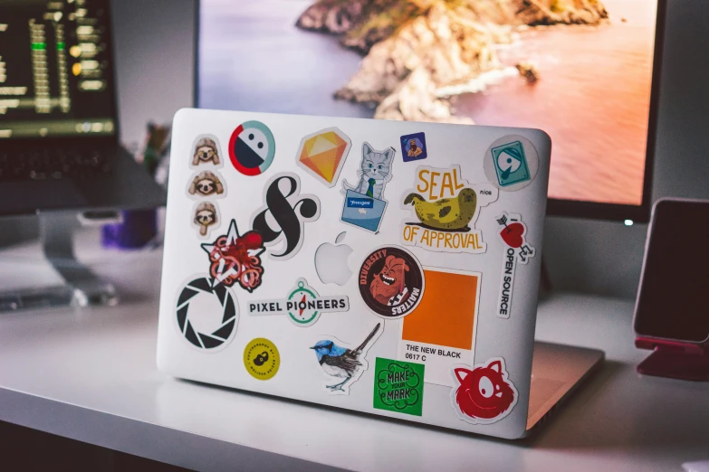 a close up of a laptop covered in stickers