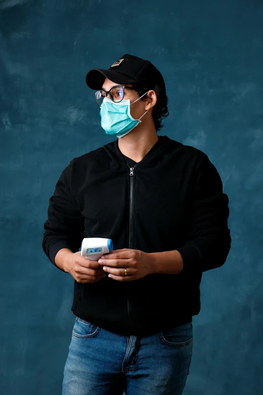 a man in black jacket and mask holding bottle of water