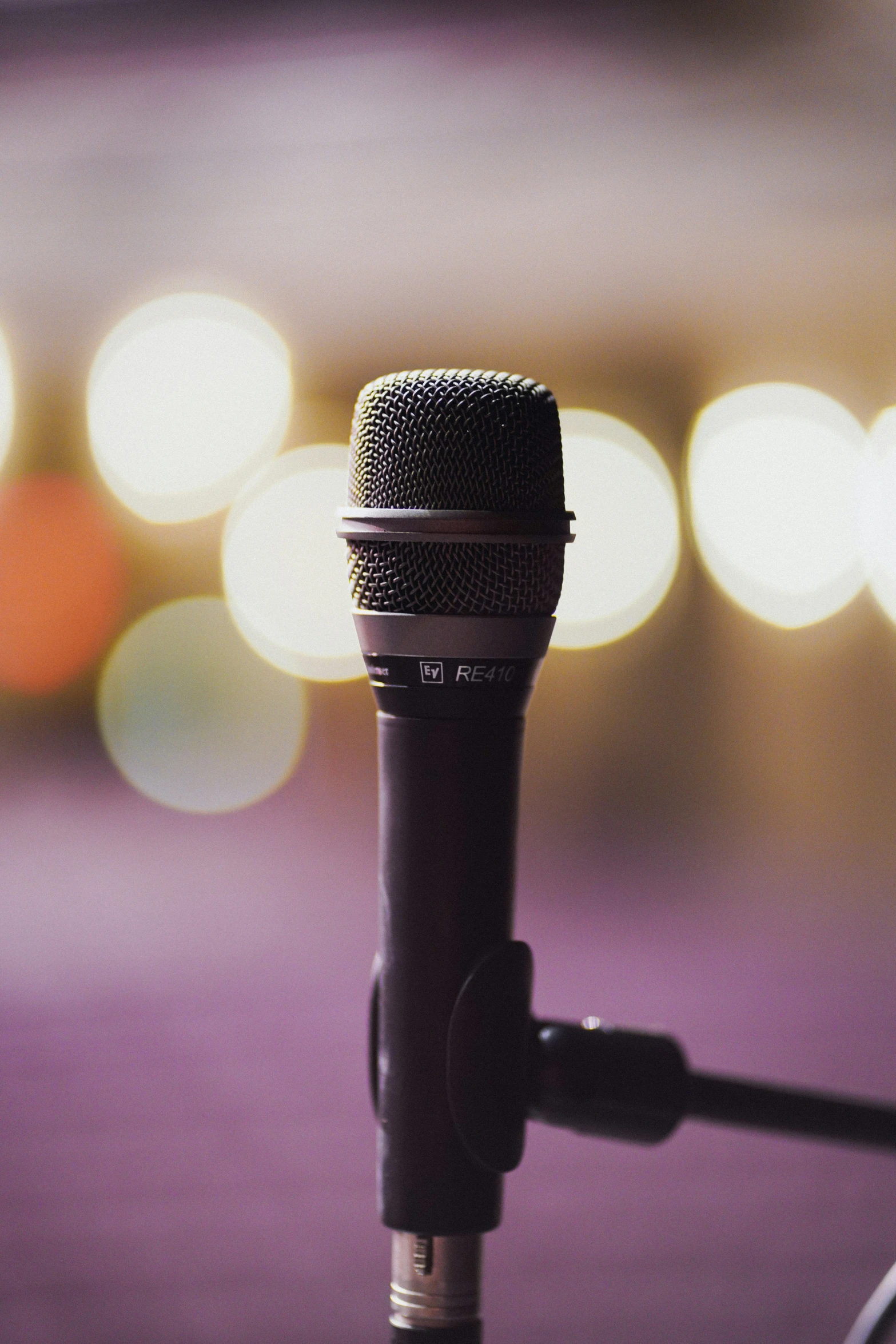 a microphone is sitting in the dark in front of blurry lights