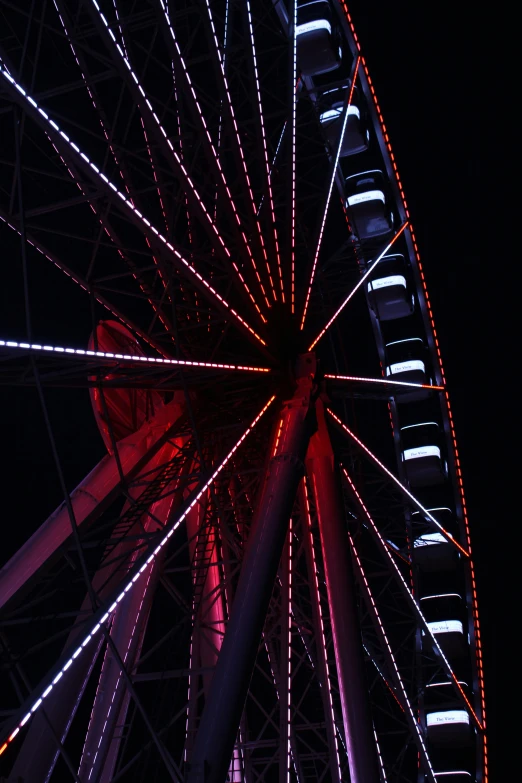 an artistic view of a ferris wheel illuminated at night