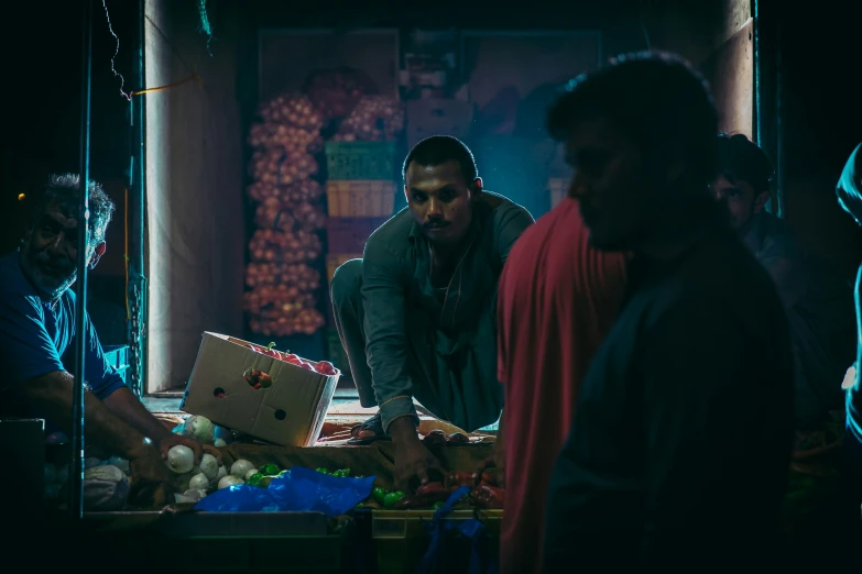 several people standing around at an outdoor produce market