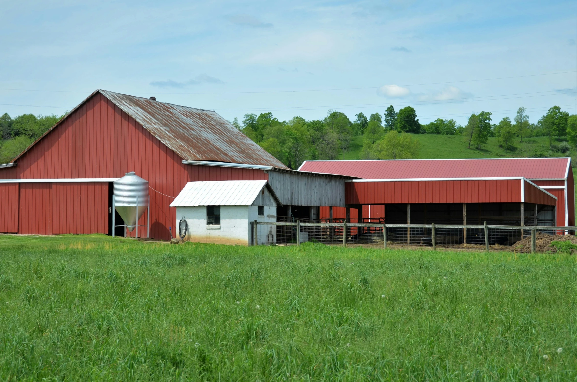 a barn in the middle of a grassy field