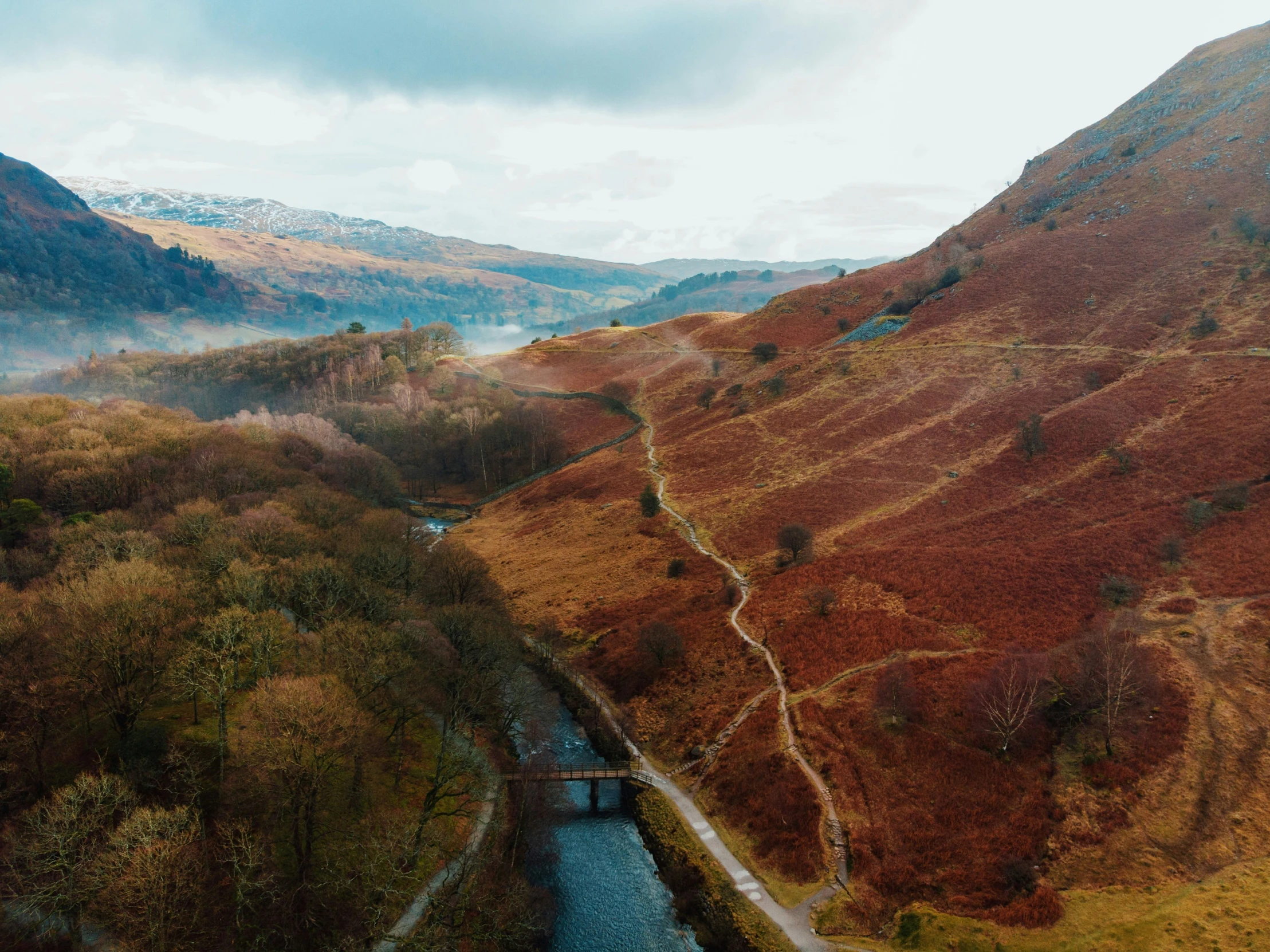 a river flowing through a lush green hillside covered in fall foliage