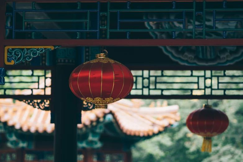 a red oriental lantern is hanging from a metal pole