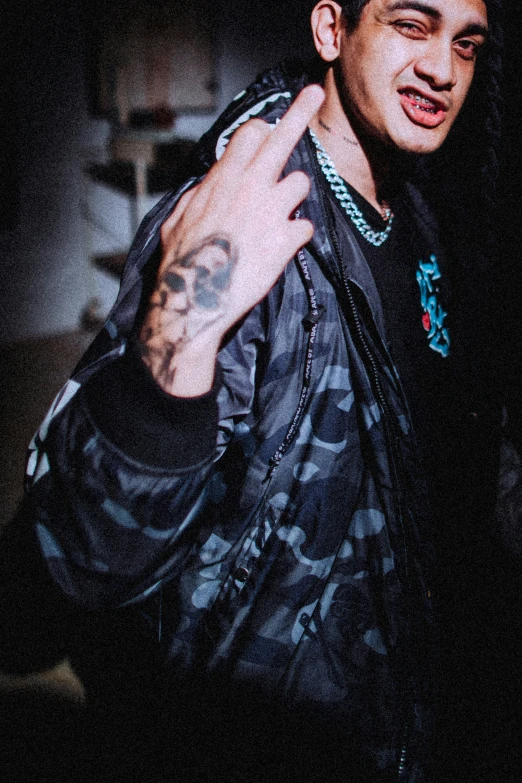 a male model wearing a black jacket with an odd skull tattoo