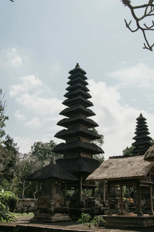 two small buildings in front of a tree