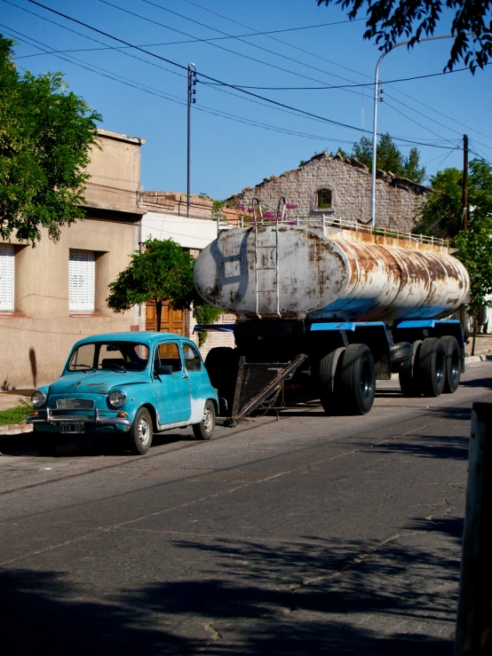 a blue truck pulling a trailer filled with tanker tanks