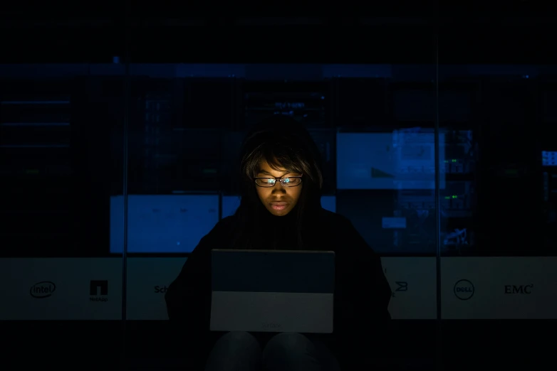 a woman sitting in front of her laptop computer