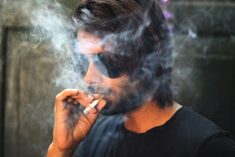 a man smoking soing with a black shirt