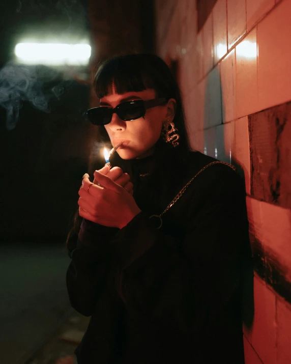 a woman wearing sunglasses holding a lit candle
