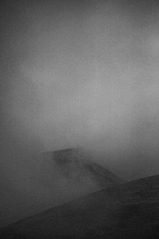 a dark, misty, hill landscape with a distant line