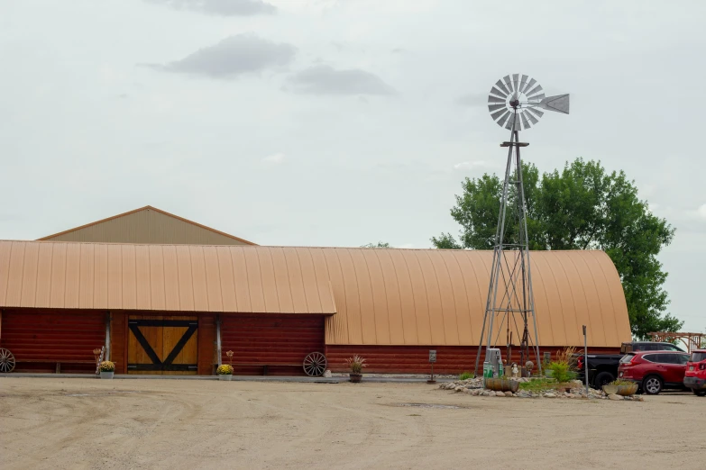 a barn with a windmill is shown in the desert