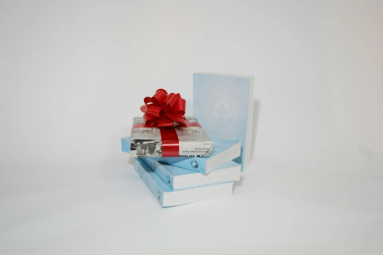 a stack of books covered in a red ribbon