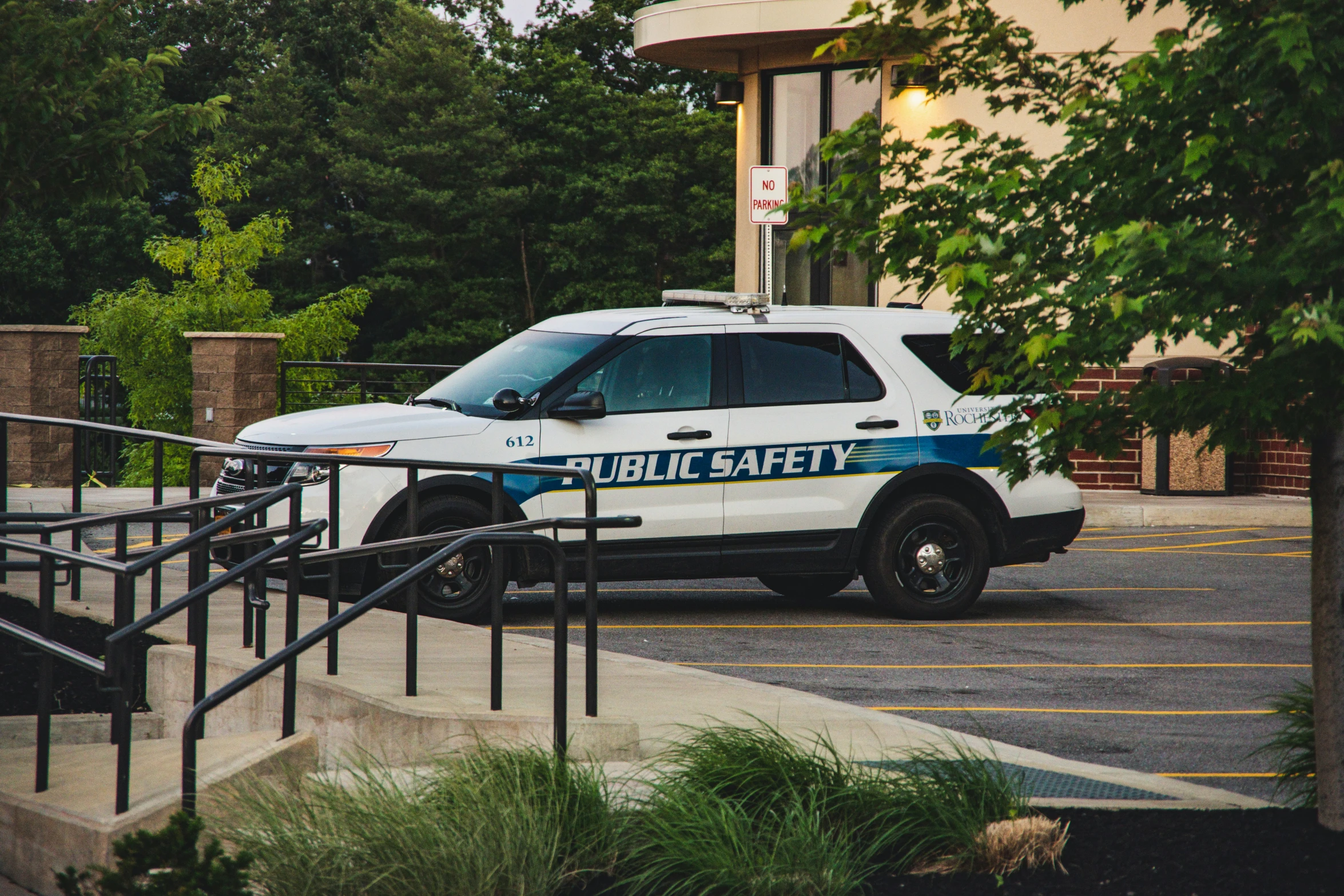 a police car is parked next to some trees