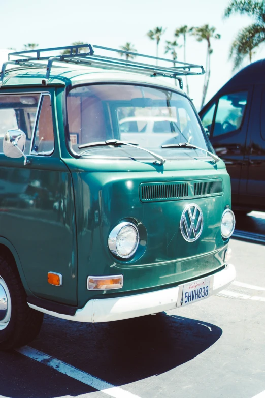 an old green van with surfboard on top of it