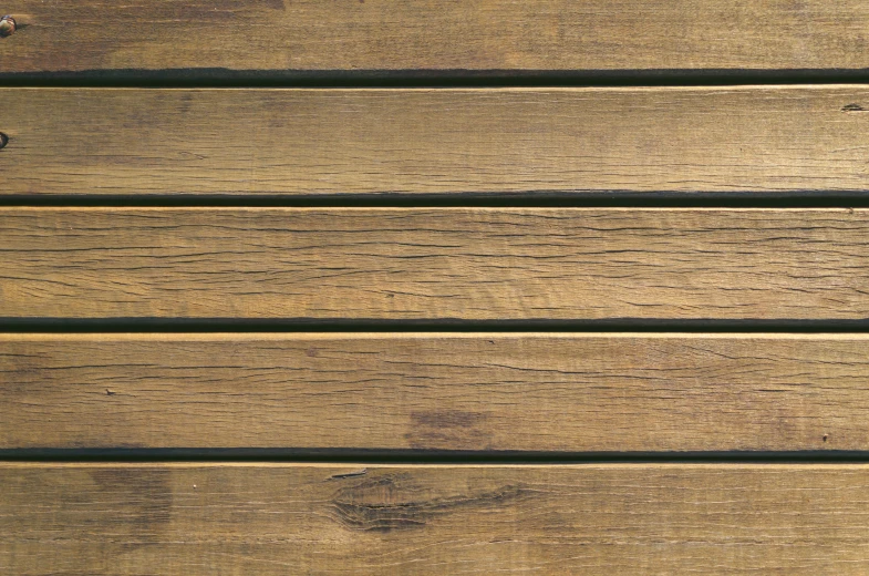 the bottom end of a wooden bench with two pieces of luggage