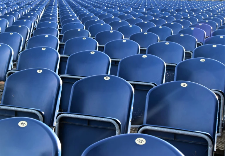 rows of blue seats with white ons and rivets