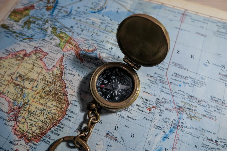 a compass sitting on top of an antique world map