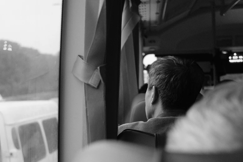 the man is looking out the window of a bus