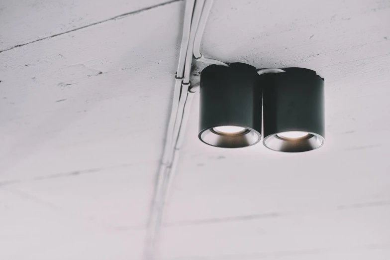 two lights with white paint on them hanging from the ceiling