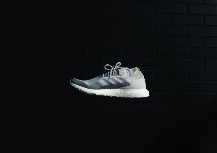 a grey adidas sneaker in the dark