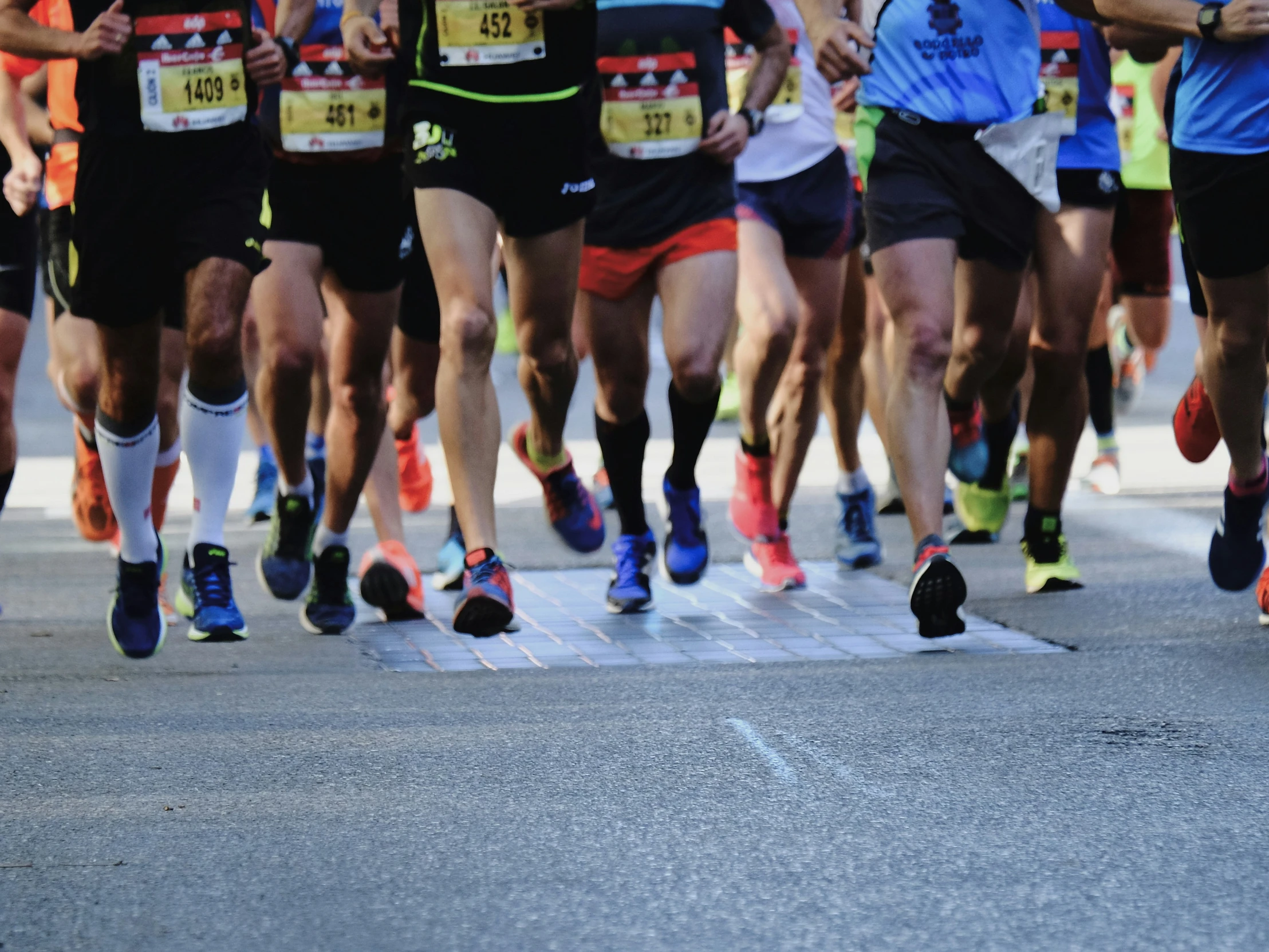 group of running competitors running across an empty street