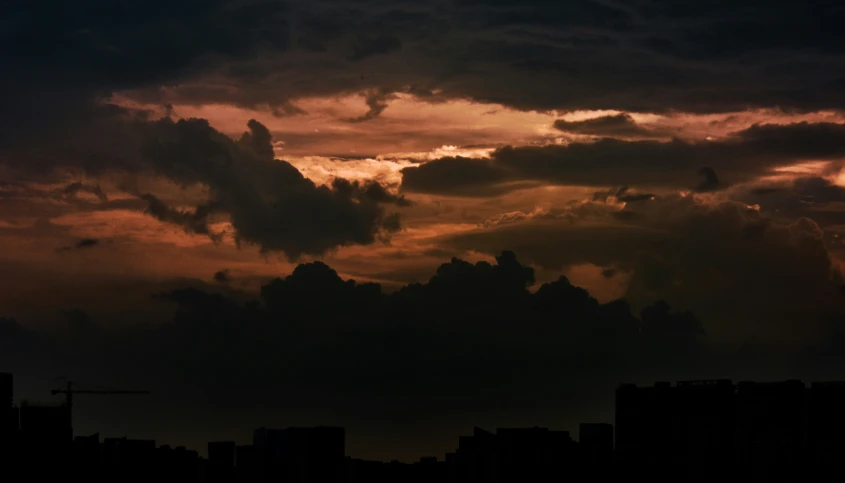 a sky with clouds and buildings and lights below