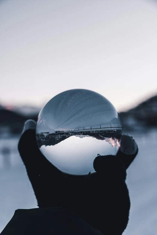 the person holds a mirror ball in their hand