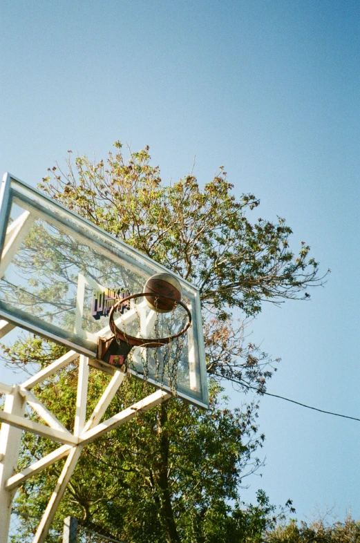 a basketball net is shown with trees in the background