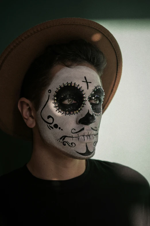 a man with a painted face is wearing a hat