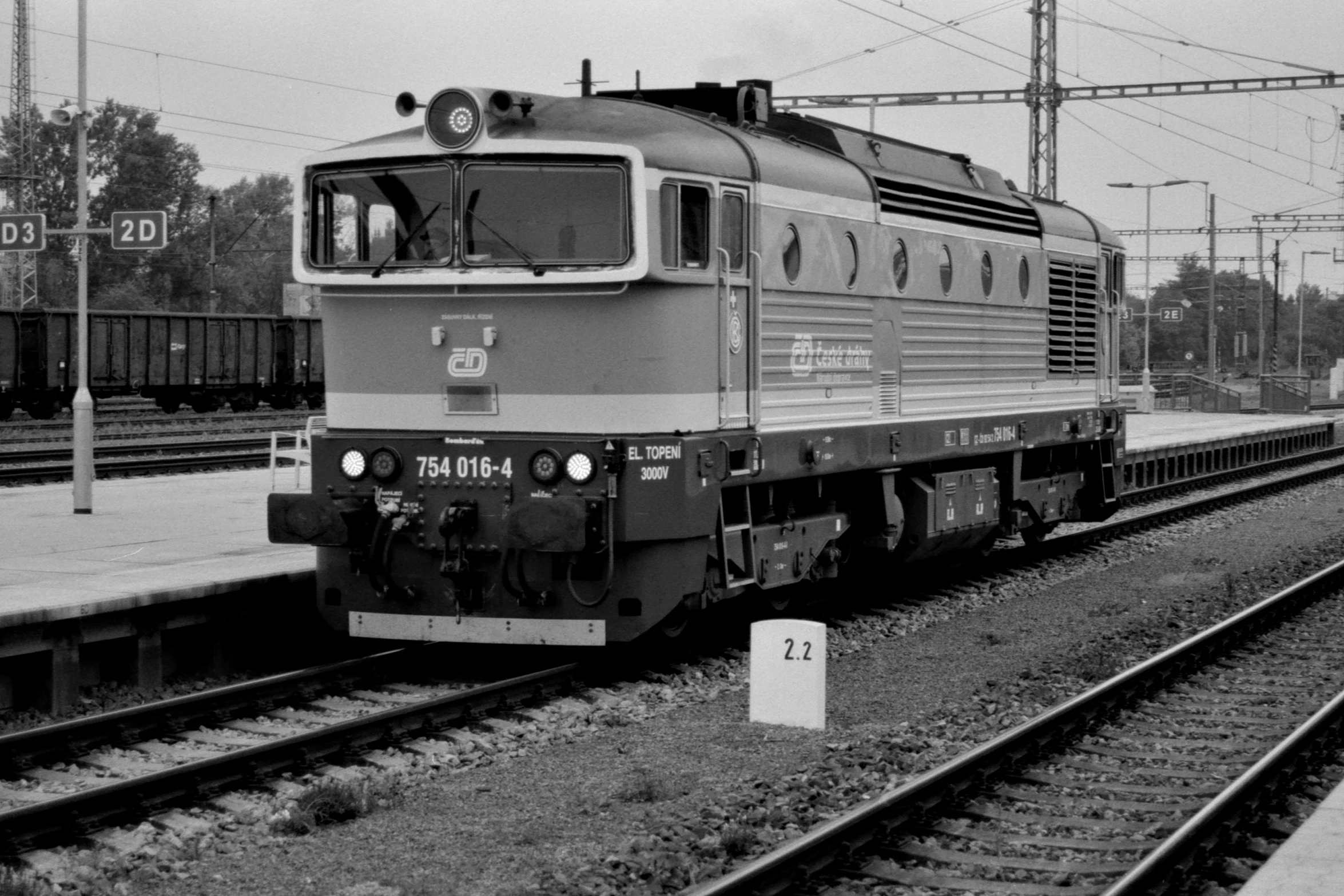 an old black and white train is on the tracks