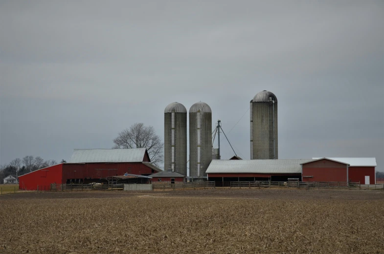 a couple of large silos sitting behind a red barn