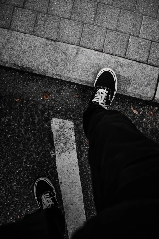 a person standing on a street with their feet up