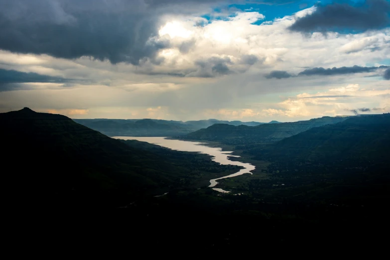 a dark colored mountain range with a river running through it