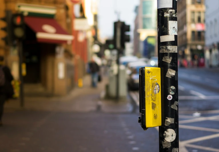 a street post has a yellow telephone in it