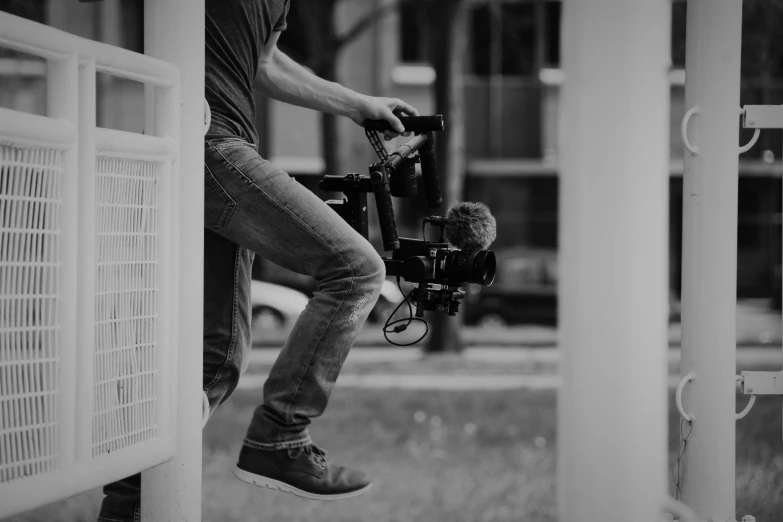 the cameraman is leaning against the fence and taking pictures