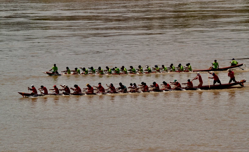 group of men in long boats on water