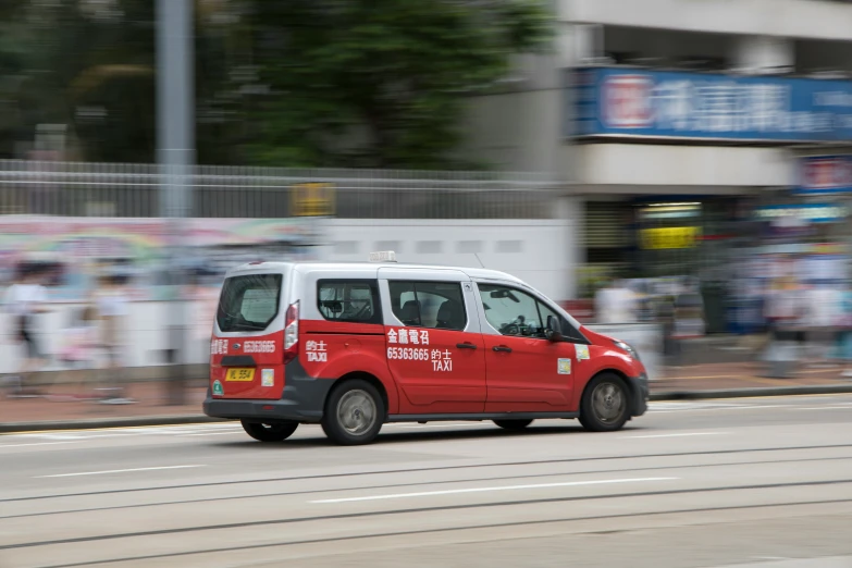 a small passenger van is going down a street